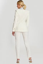 Back view of fitted white suit with structured seams and rhinestone collar