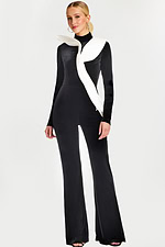 Front view of black velvet jumpsuit with white sculptural ruffle detail