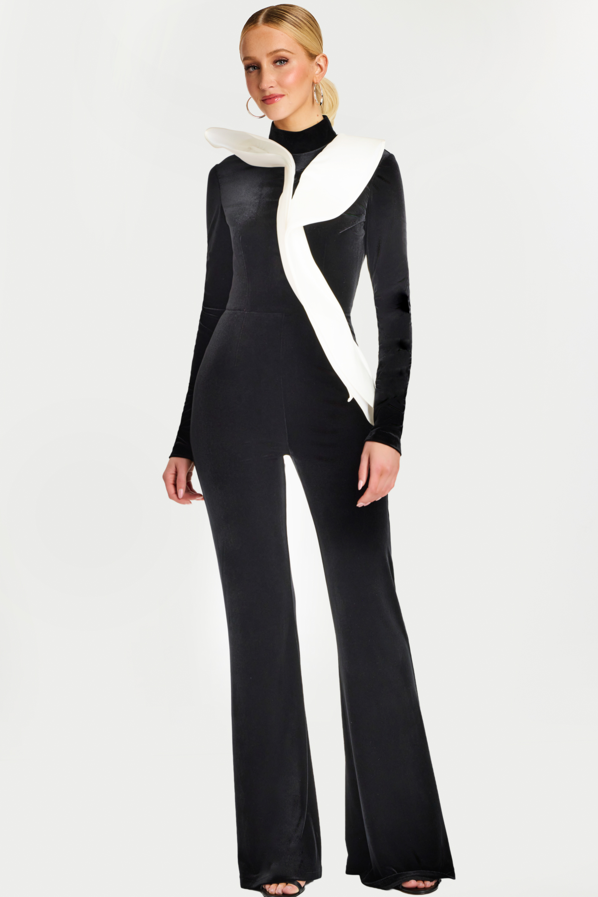 46282_BLACKWHITE_1 Front view of black velvet jumpsuit with white sculptural ruffle detail