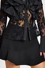Model showing side and back view of ruffled lace top with flared short black skirt