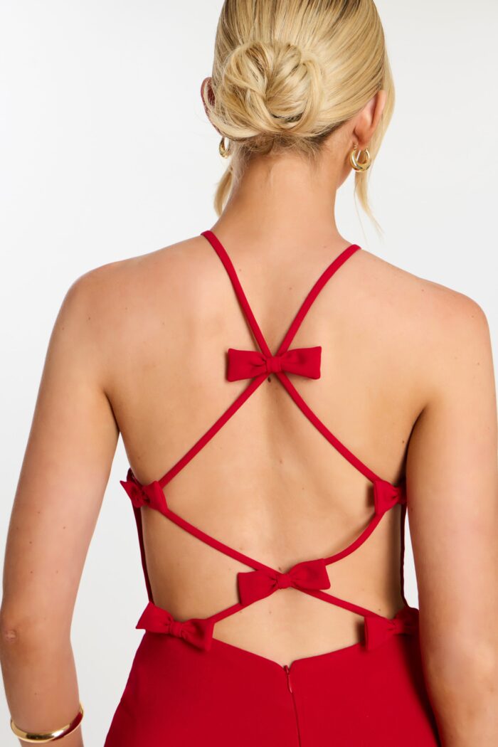 Close-up of strappy open back with five decorative red bows