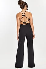 Back view of black jumpsuit featuring crisscross straps and bow accents