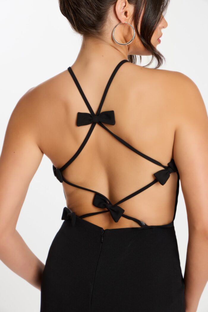 Close-up of strappy open back on black jumpsuit with multiple bows