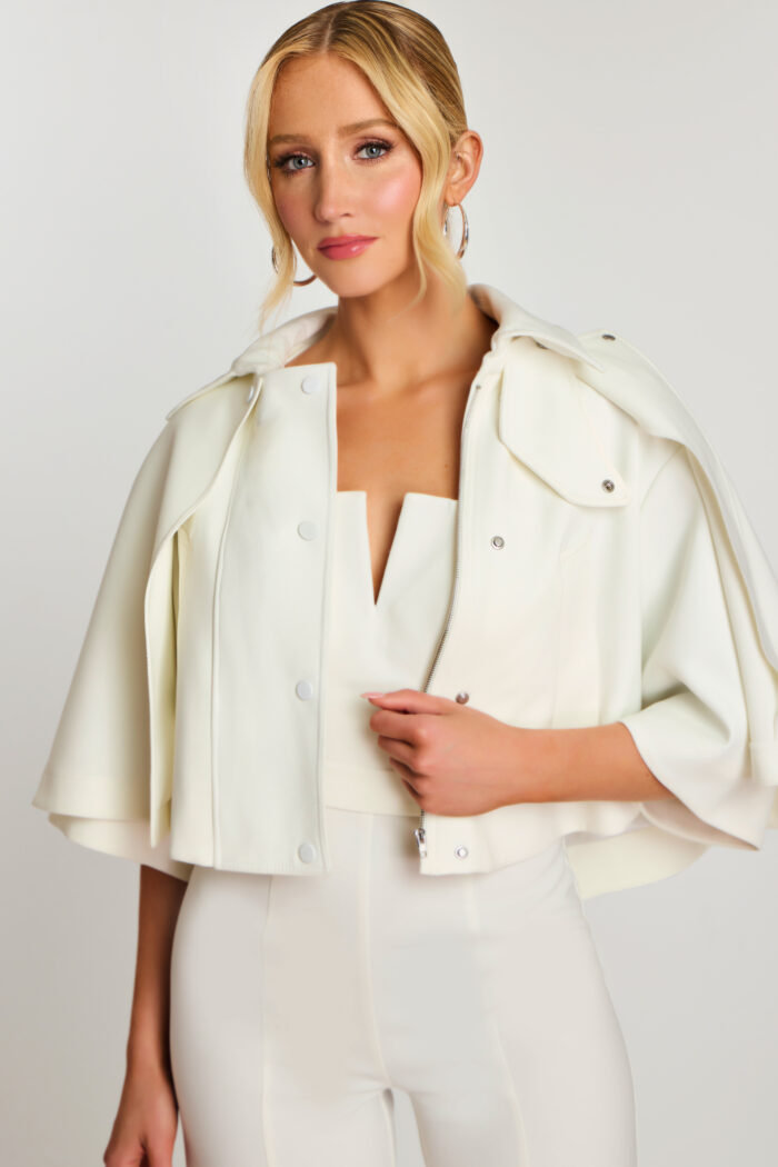 Side close-up showing V-notch neckline and metal zip of bridal cape