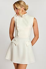 Side angle of sleeveless ivory dress with flared skirt and flap pockets