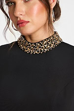 Close-up of beaded high neckline on sleeveless black mini dress