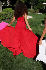 strapless black gown with gold floral waist detail - back view, holding billowing pleated skirt