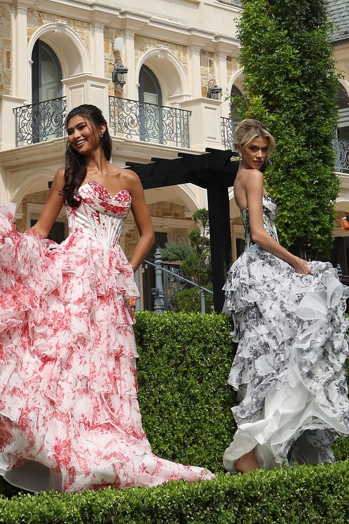 strapless floral ball gown with ruffled skirt - two girls front, brunette smiling, blonde looking back