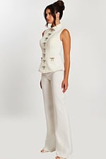 Side view of ivory structured top and flared pants with embellished bows