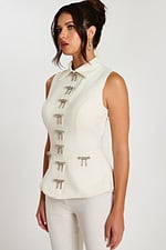 Close-up side angle showing rhinestone bow details on ivory tailored top