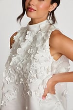 Detail of pearl-centered floral appliqués on textured satin fabric