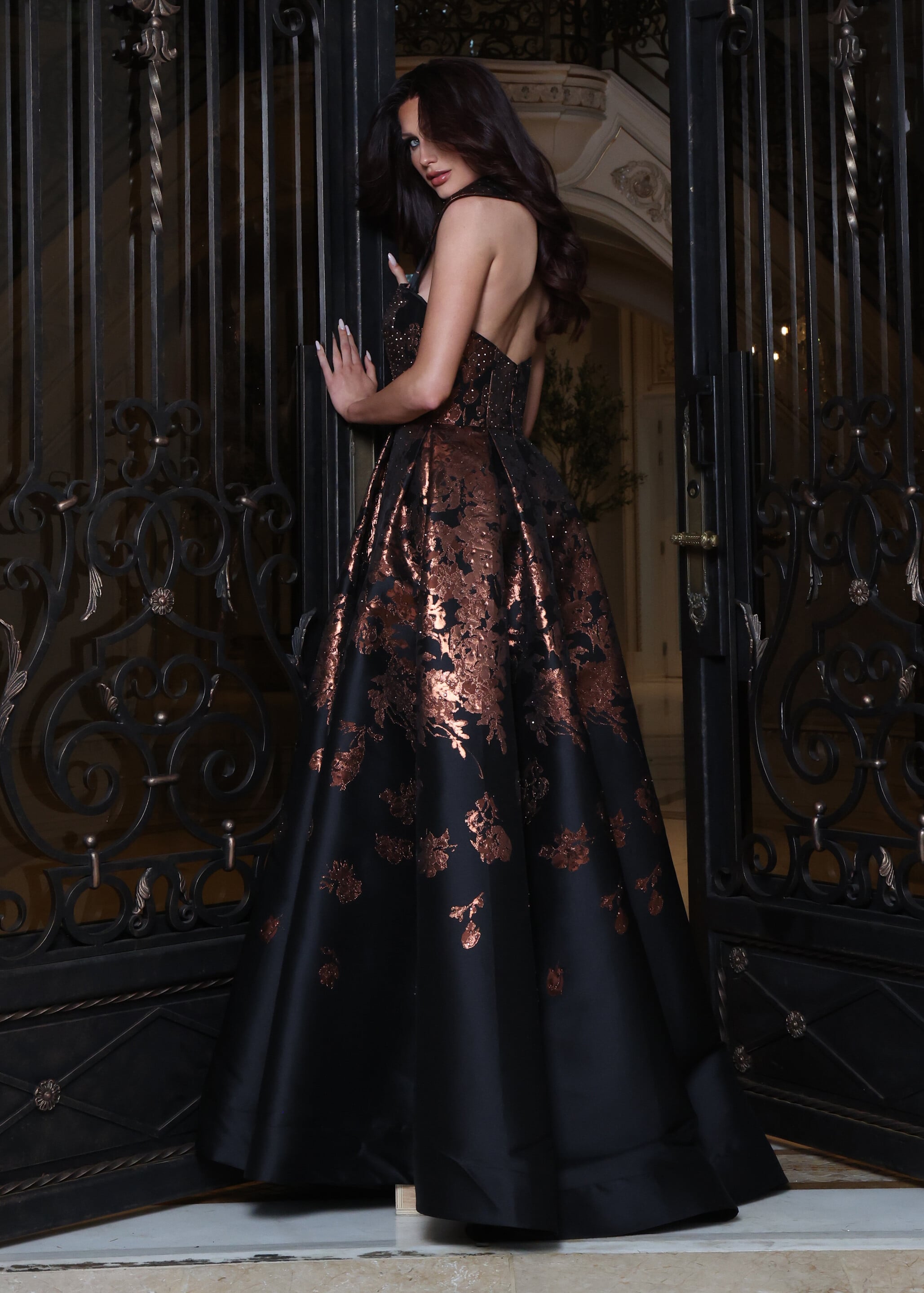 Black strapless gown with bronze floral jacquard pattern, side view