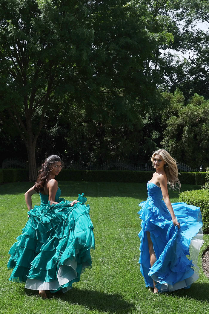 ruffled strapless tiered prom dress - two girls front, both looking back dresses flowing