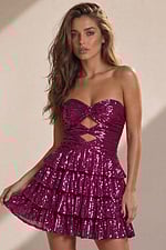 Strapless magenta sequin mini dress with a twisted bodice and double diamond-shaped cut-outs at the center.