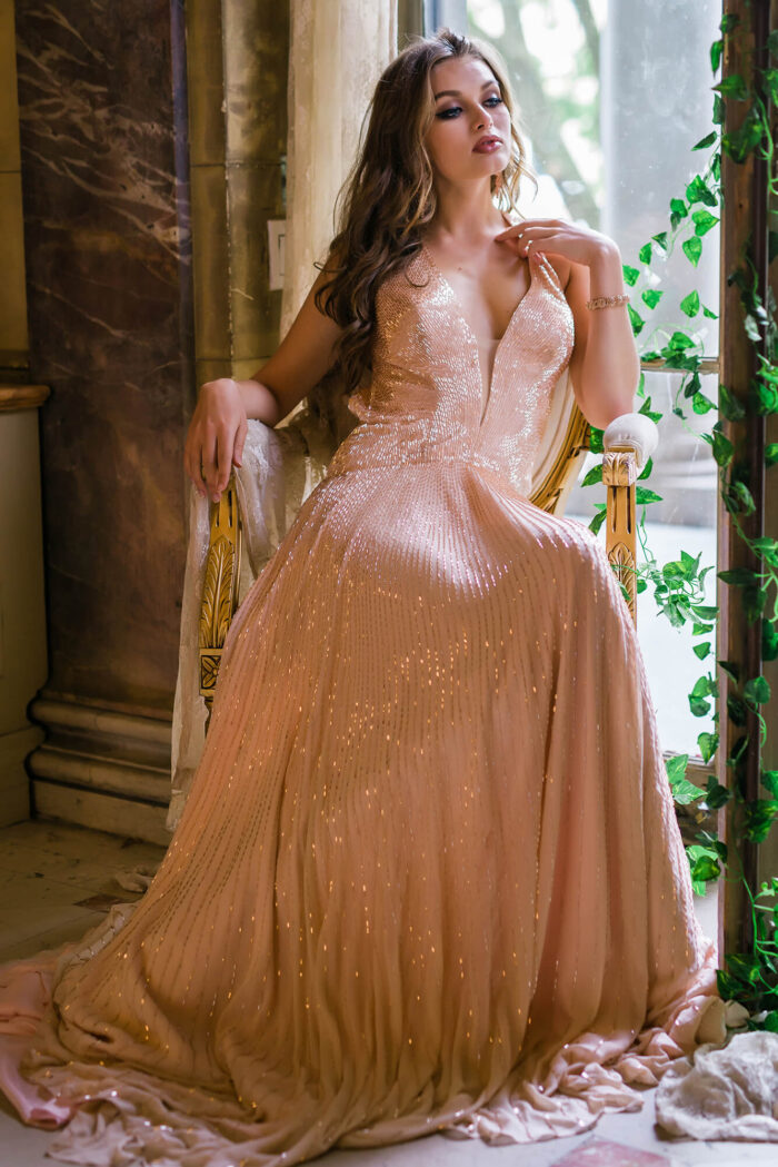 Model wearing Jovani 47780 beige dress with plunging V-neckline and flowing silhouette