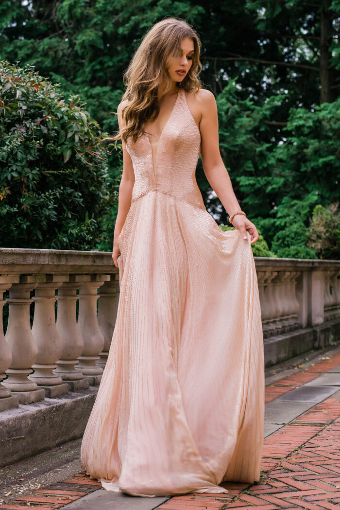 Back view of model in Jovani 47780 beige dress with open back design
