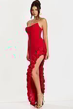 Side angle of red evening gown with sculpted bodice and 3D rosettes cascading from slit