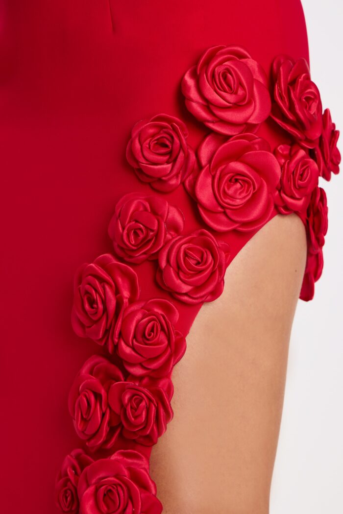 Close-up of satin rosette detailing on red high-slit gown
