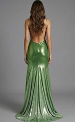 Back view of a fitted gown with an open back, thin straps, and a floor length skirt with subtle sparkle