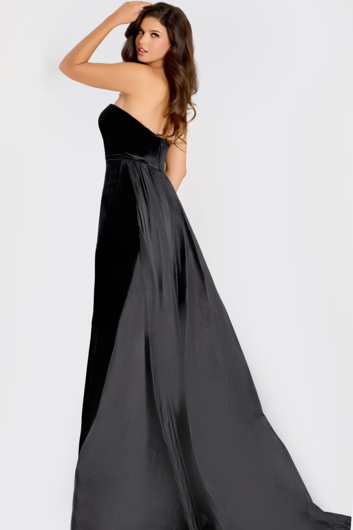 Strapless gown featuring a velvet bodice with a flowing satin overskirt and long train, creating an elegant and timeless evening look.