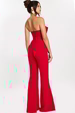 Rear side view of red fitted jumpsuit showing flared pant and open back