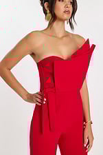 Close-up of structured bodice with folded detail and tied waist on red jumpsuit
