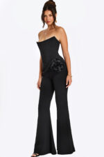 Strapless black jumpsuit with satin rosette detail at the hip