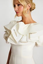 Close-up of ruffled shoulder with pearl-embellished safety pins