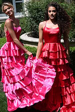 tiered satin dress with spaghetti straps - two girls front, hot pink red dresses holding skirts