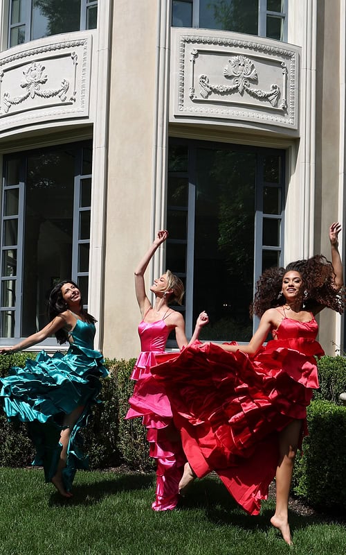 tiered satin dress with spaghetti straps - three girls front, smiling jumping arms raised barefoot