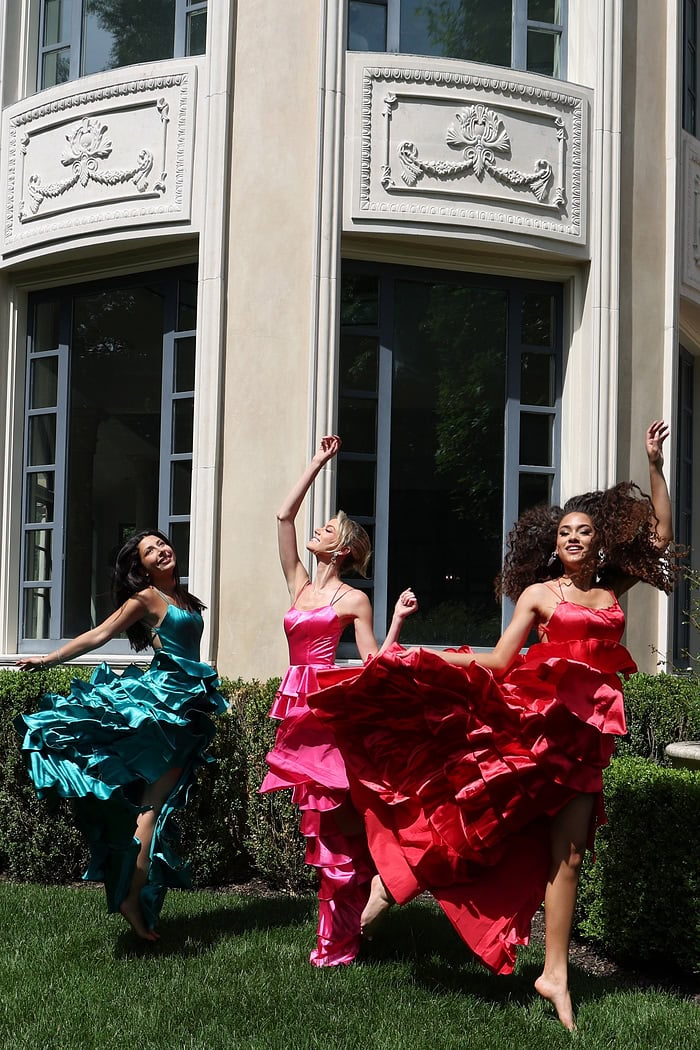 tiered satin dress with spaghetti straps - three girls front, smiling jumping arms raised barefoot
