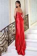 red beaded corset satin prom dress with high slit - three quarter view, looking over shoulder on stairs