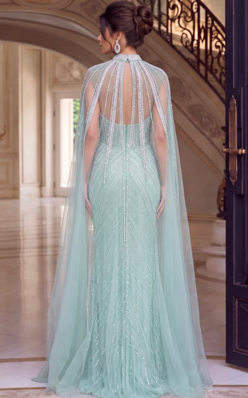 Seafoam beaded gown shown from the back with cape falling over the sweep train