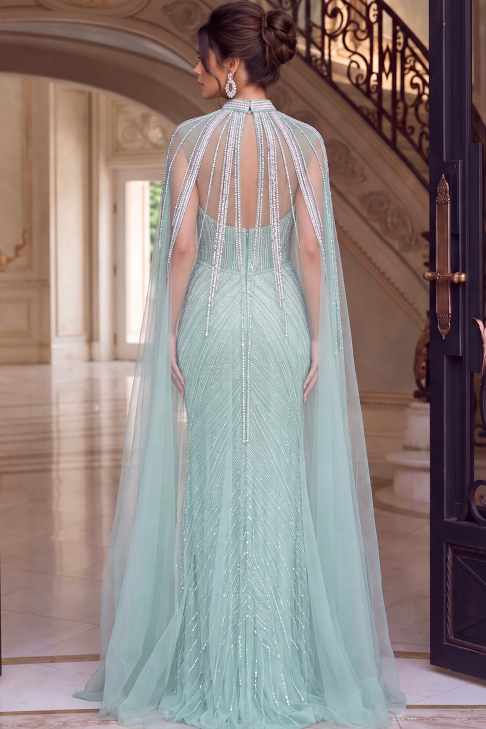 Seafoam beaded gown shown from the back with cape falling over the sweep train