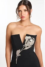 Close-up of rhinestone rose embellishment on black V-neck strapless dress