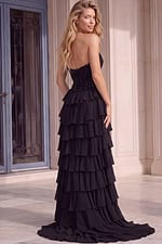 Back view of a black strapless gown with a glittering beaded bodice, open back design, tiered ruffle skirt accents, and a sweeping floor-length train.