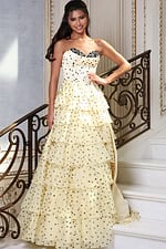 champagne strapless polka dot tiered gown - front full body, smiling hand on hip dark hair on stairs