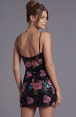 form-fitting black mini dress with vibrant pink and purple sequin flower motifs and adjustable spaghetti straps.