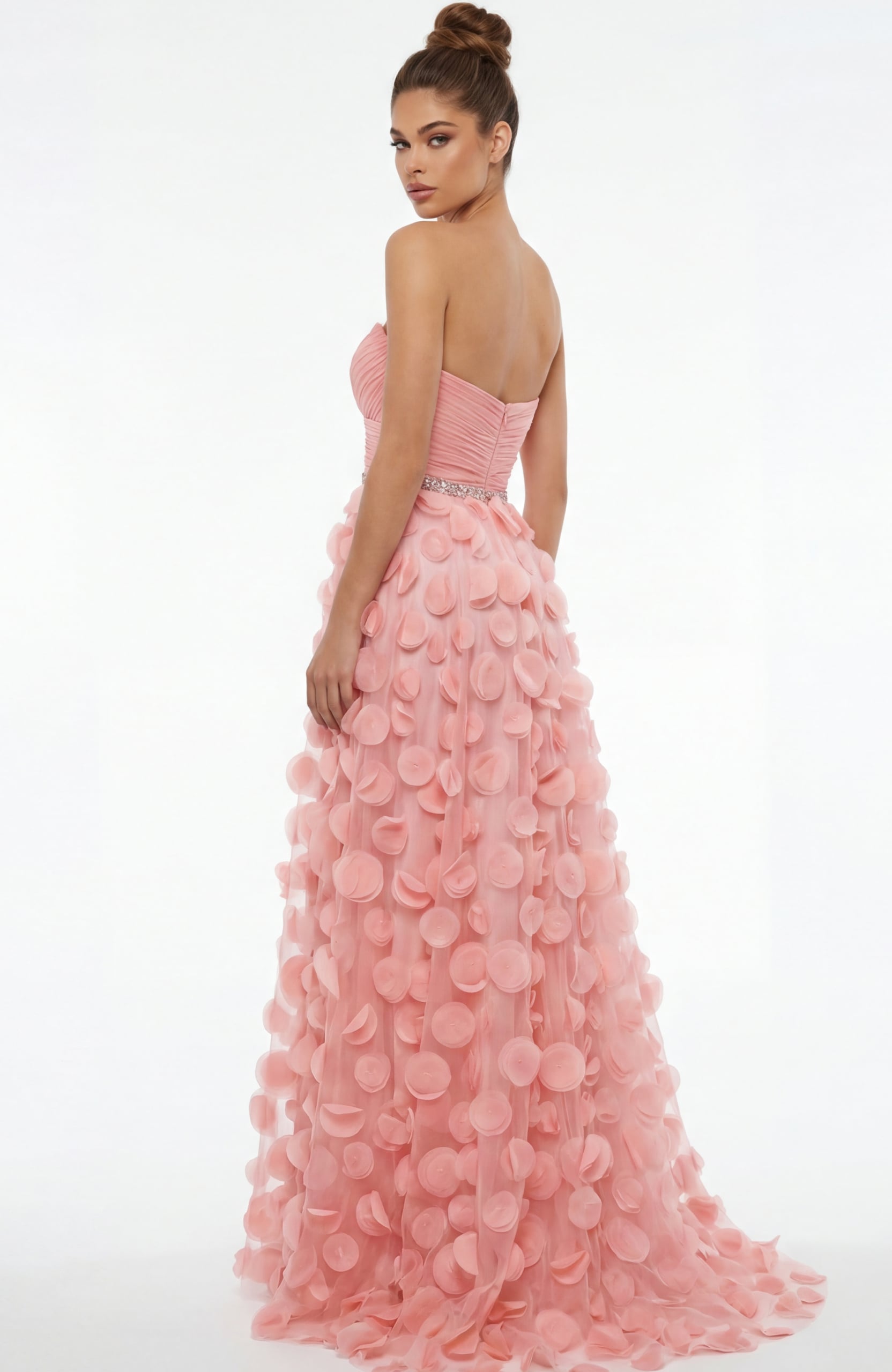 Back view of strapless gown with ruched bodice, beaded waist, and flowing skirt covered in soft circular appliqués