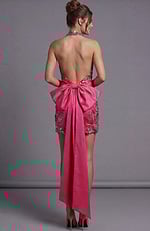 Open-back pink sequin mini dress accented by a massive satin bow at the lower back.