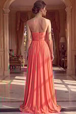 Coral chiffon bridesmaid dress featuring a strapless neckline with shimmering embellishments and a cinched beaded waist.