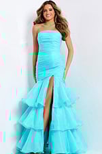 Elegant aqua evening dress featuring tiered organza ruffles and dramatic bow detail.