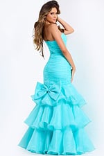 Strapless mermaid gown with ruched bodice, layered ruffle skirt, and thigh slit.