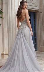 Back view of beaded halter style dress with open back, fitted waist, and flowing sheer overskir