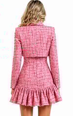 Back view of a coordinated pink tweed set showing the tailored fit of the cropped jacket and the ruffled silhouette of the matching mini dress.