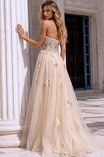 Back view of a blush champagne formal dress with a lace corset bodice
