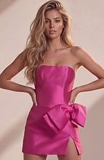 pink satin party dress showcasing corset-like vertical boning and a massive side bow detail.