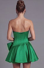 Structured strapless dress with a dropped waistline and a decorative architectural bow at the side.