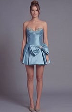 Sleek strapless cocktail dress showcasing a fitted silhouette and a voluminous flared bow detail.