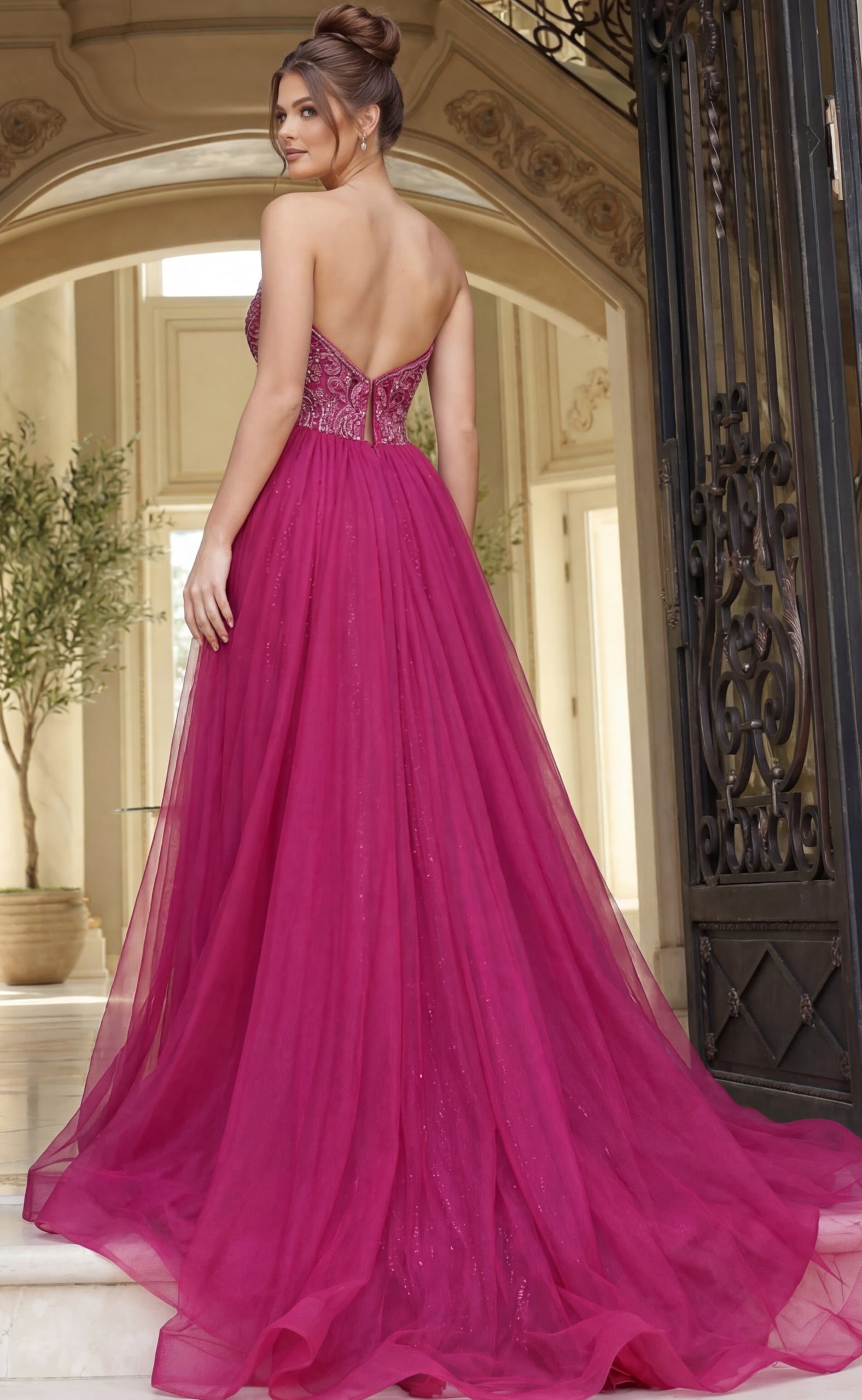 Back view of strapless beaded evening gown with low back, fitted waist, and flowing tulle skirt